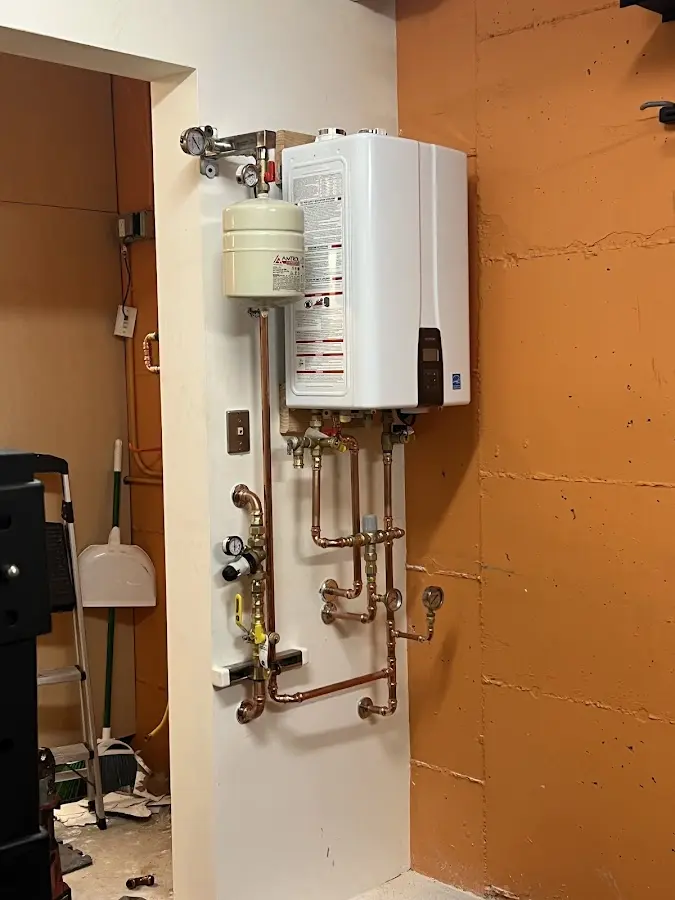 Plumbing technician inspecting water heater connections in Potter
